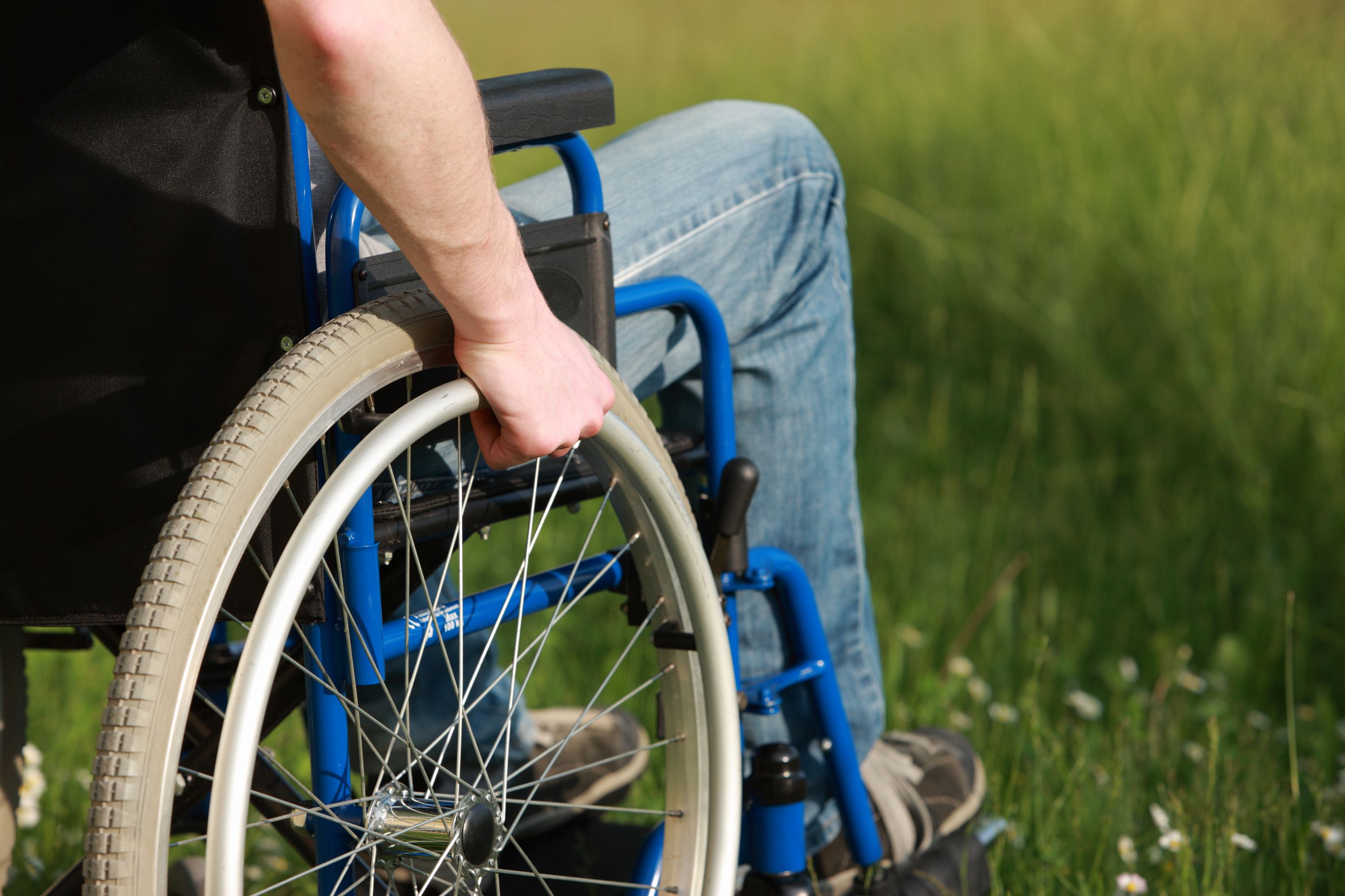 Person using a blue manual wheelchair outdoors