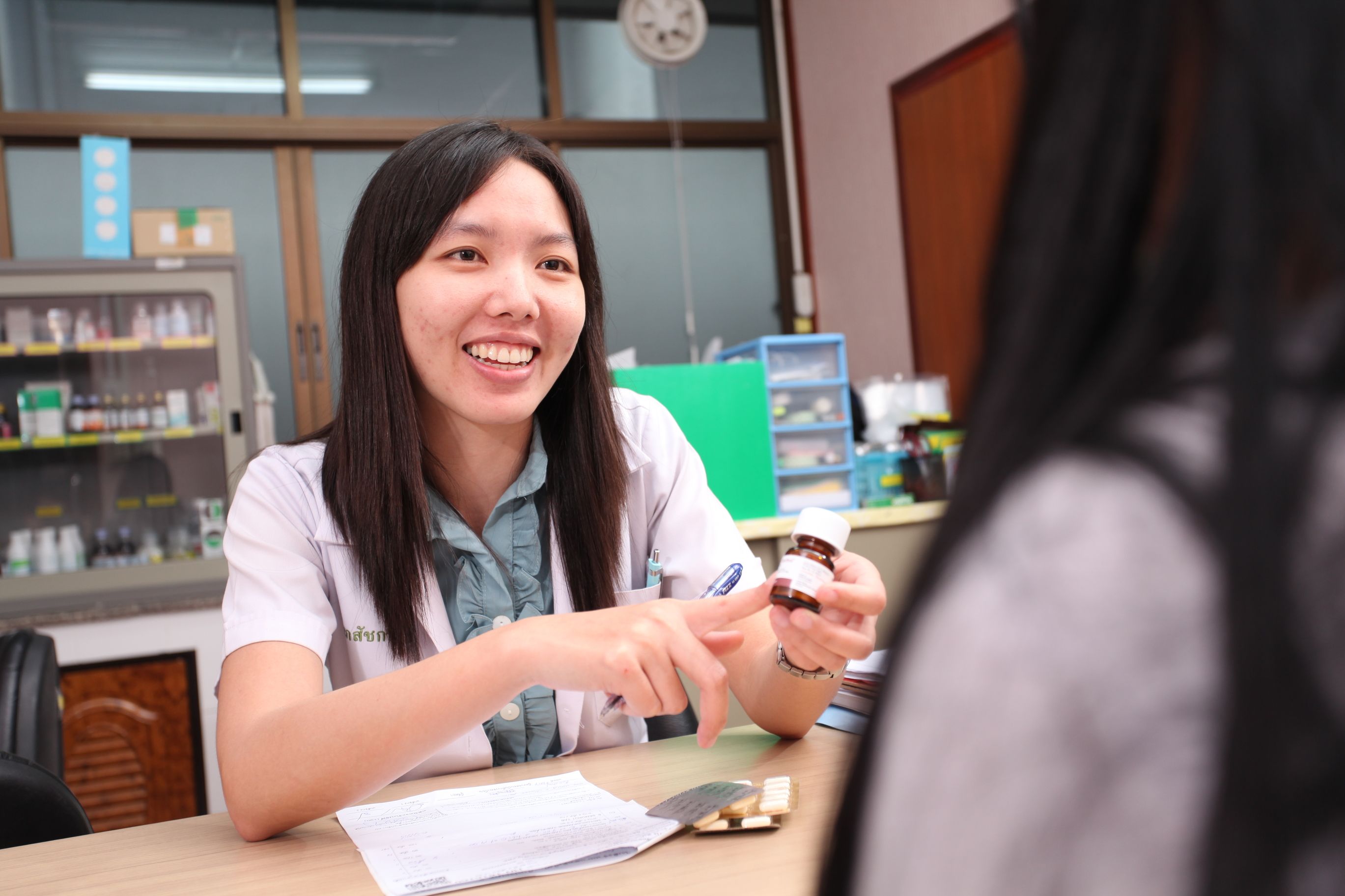 Pharmacist discussing a medication bottle with a patient