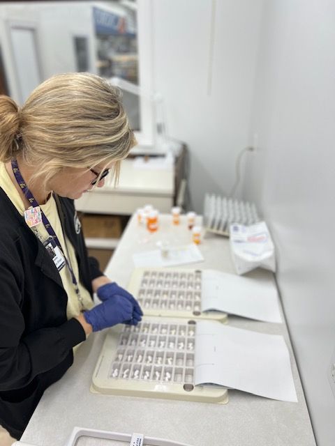 Pharmacy staff member preparing multi-dose pill packs